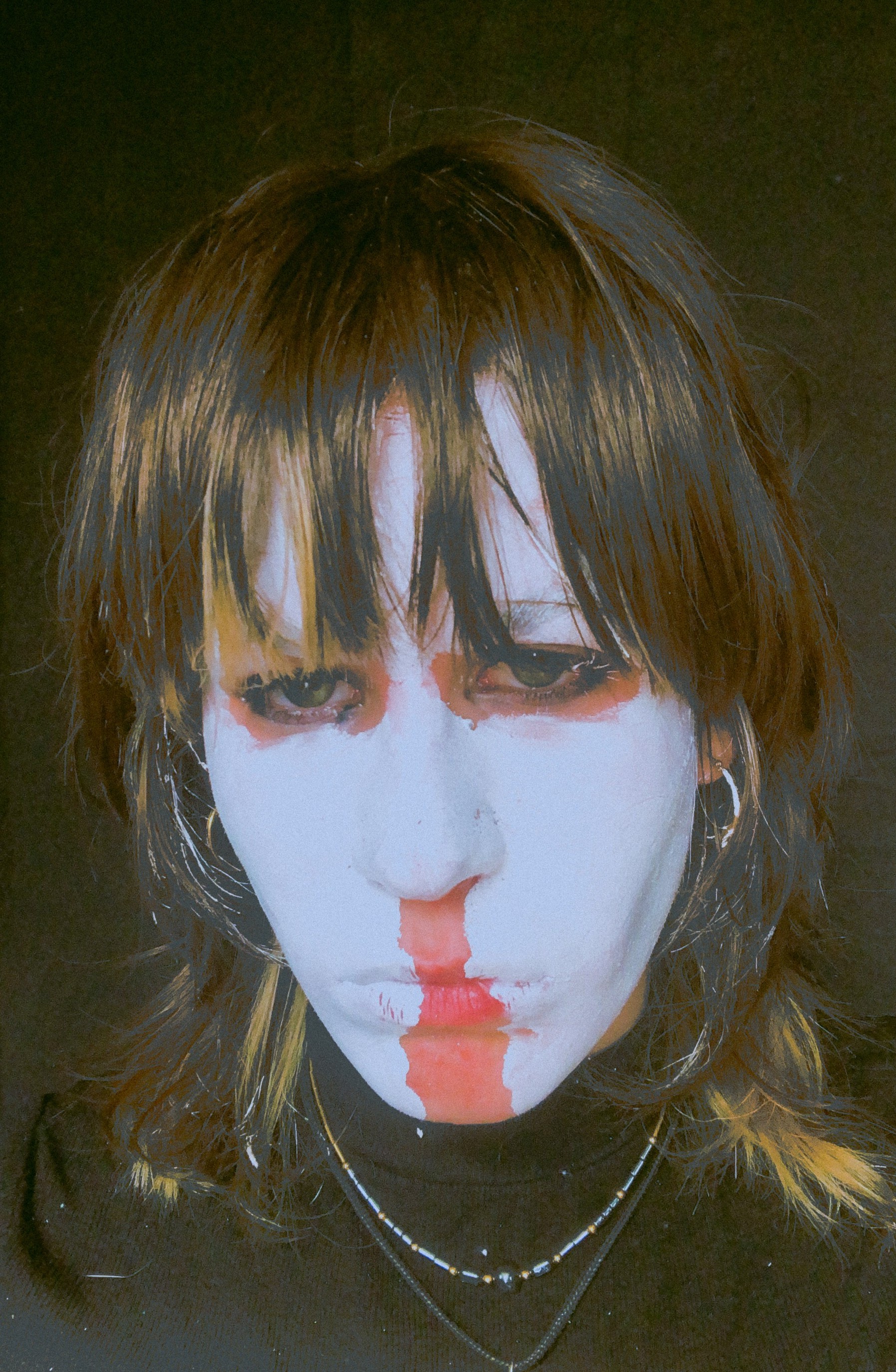 photo of ed with white facepaint, brown hair and green eyes in a black shirt on a black background.